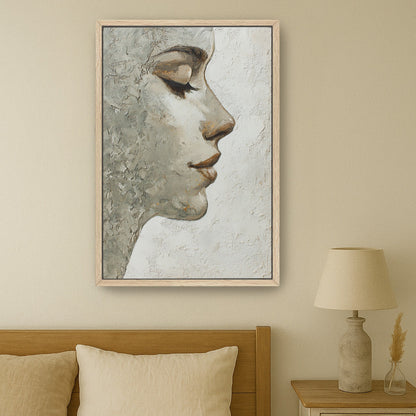 Oak-framed feminine portrait wall art hanging above neutral bed in minimalist bedroom setting.