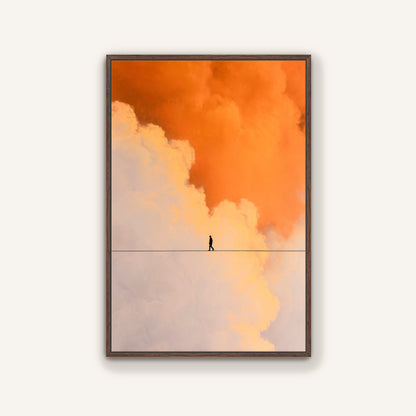 Warm walnut frame wall art depicting a human silhouette crossing a fine line amid orange and pastel clouds.
