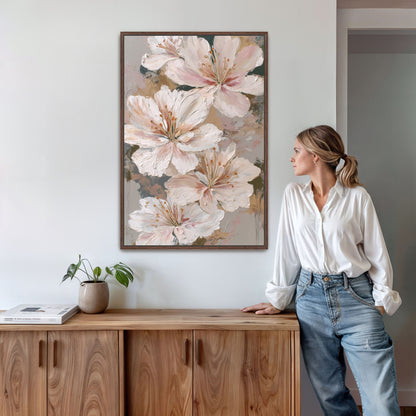 Ivory and blush floral wall art framed in dark wood, displayed in a warm modern home interior beside a woman in a white blouse.