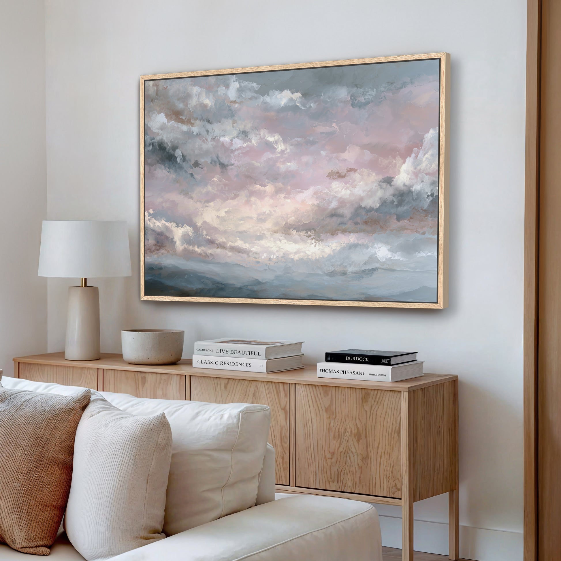 Ethereal pink sky wall art framed in light wood, styled in a modern living room.